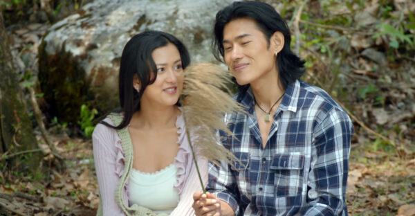 Upasana Singh Thakuri and Sonam Topden sitting beside a tree, with Sonam holding a feathery grass stem, in the Jalaaki trailer.