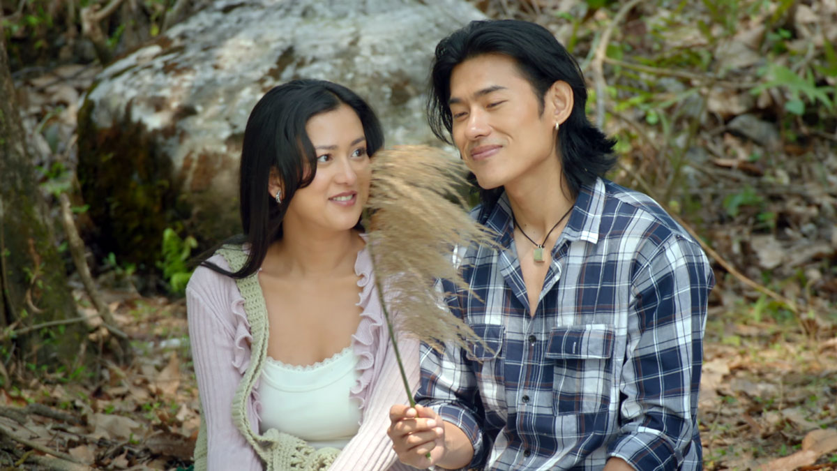 Upasana Singh Thakuri and Sonam Topden sitting beside a tree, with Sonam holding a feathery grass stem, in the Jalaaki trailer.